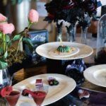 Elegant dessert presentation with dark floral décor and artistic plating.