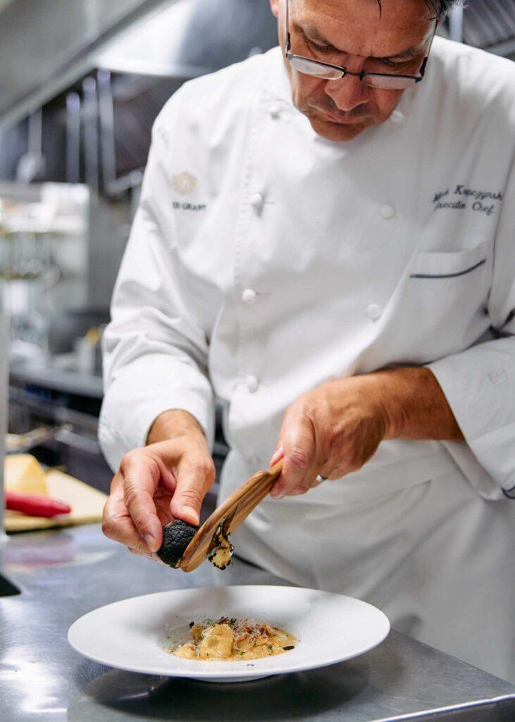 chef seasoning food on a plate