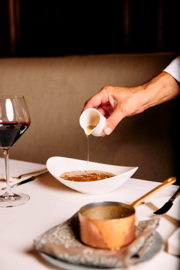 chef pouring a liquid into a bowl