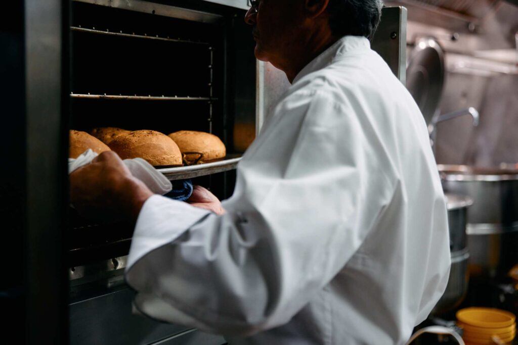 chef removing breads from the oven