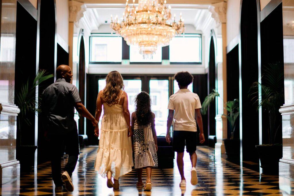 a family of four walking down a hallwa