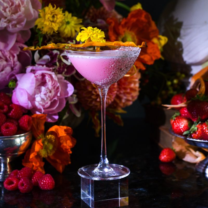 a table topped with a martini glass filled with liquid
