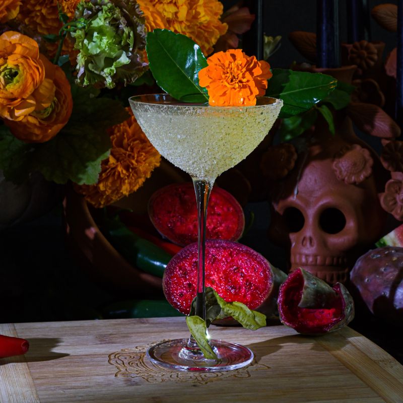 a table topped with a martini glass filled with liquid