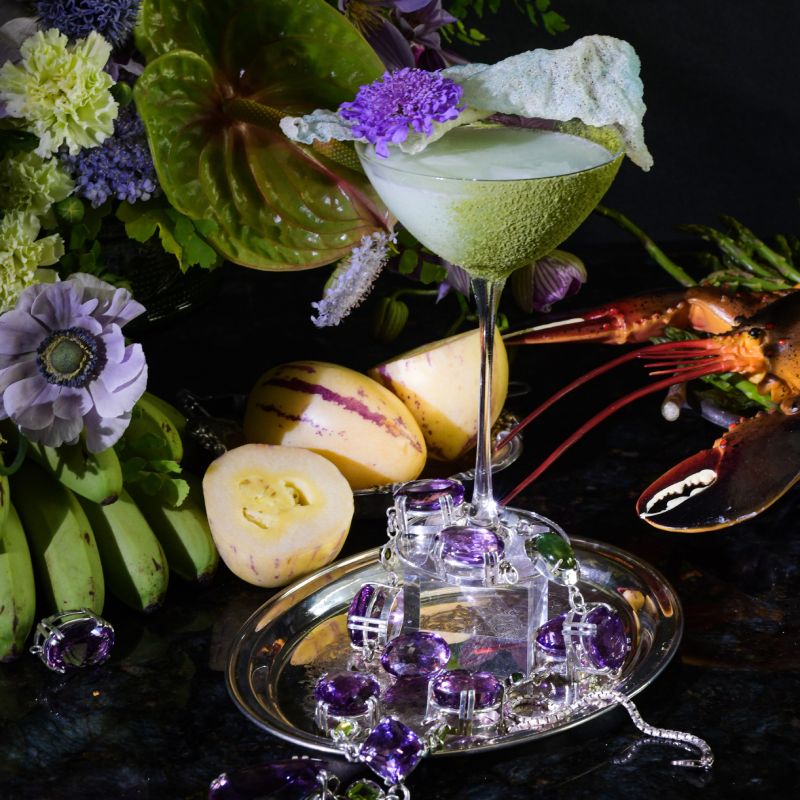 a table topped with a martini glass filled with liquid