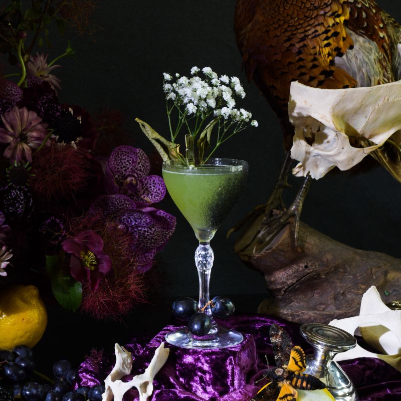 a table topped with a martini glass filled with liquid
