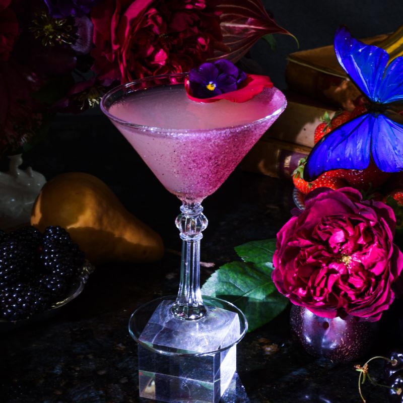 a table topped with a martini glass filled with liquid